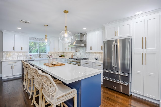 7 Long View Dr, Wading River, NY 11792 - kitchen featuring high quality appliances, wall chimney exhaust hood, white cabinets, a breakfast bar, and decorative backsplash