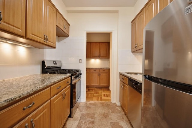 10 Lake St Unit 4E, White Plains, NY 10603 - kitchen with appliances with stainless steel finishes, light stone counters, tasteful backsplash, and brown cabinets