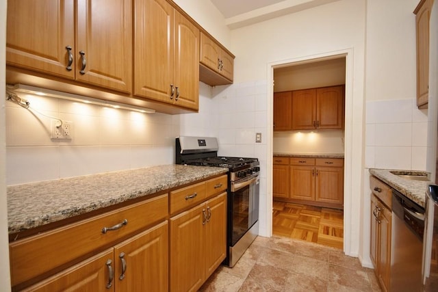10 Lake St Unit 4E, White Plains, NY 10603 - kitchen with stainless steel appliances, light stone counters, tasteful backsplash, and brown cabinets