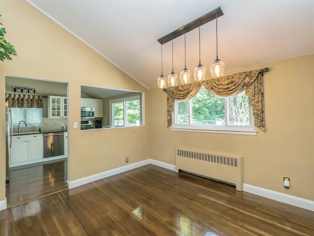 1 Barry Dr, Glen Cove, NY 11542 - unfurnished dining area with radiator, vaulted ceiling, dark wood finished floors, and ornamental molding