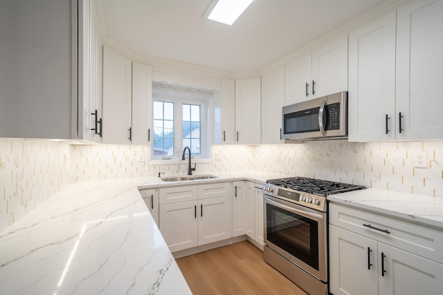 67-23 182nd St, Fresh Meadows, NY 11365 - kitchen featuring stainless steel appliances, light wood-type flooring, white cabinets, and backsplash