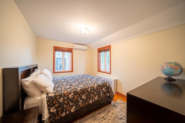 67-23 182nd St, Fresh Meadows, NY 11365 - bedroom with a wall unit AC, wood finished floors, multiple windows, radiator, and lofted ceiling