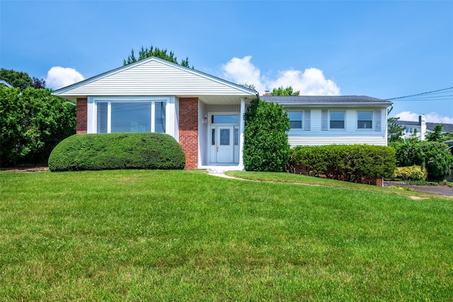 108 Kensington Oval, New Rochelle, NY 10805 - view of front of property featuring brick siding, a front yard, and a garage