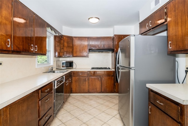 108 Kensington Oval, New Rochelle, NY 10805 - kitchen featuring stainless steel appliances, under cabinet range hood, light countertops, and light tile patterned flooring