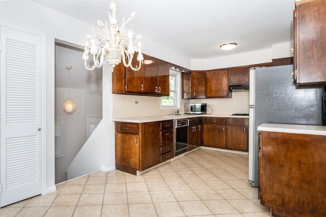 108 Kensington Oval, New Rochelle, NY 10805 - kitchen with stainless steel appliances, light countertops, a chandelier, and under cabinet range hood
