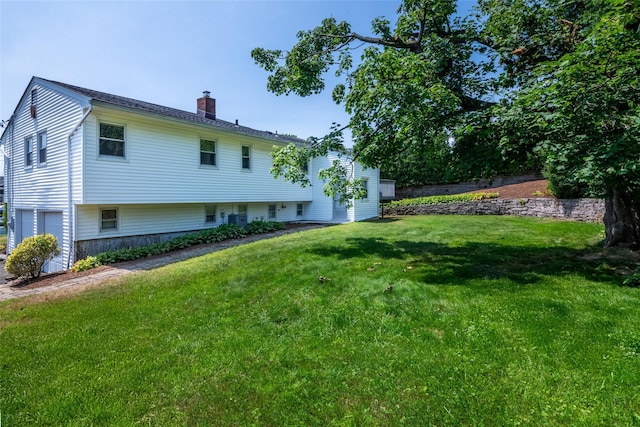 108 Kensington Oval, New Rochelle, NY 10805 - back of property with a chimney, a lawn, and a garage