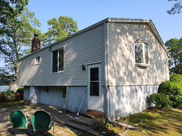 11 Hart St, Port Jefferson Station, NY 11776 - back of property featuring a chimney, entry steps, and a patio