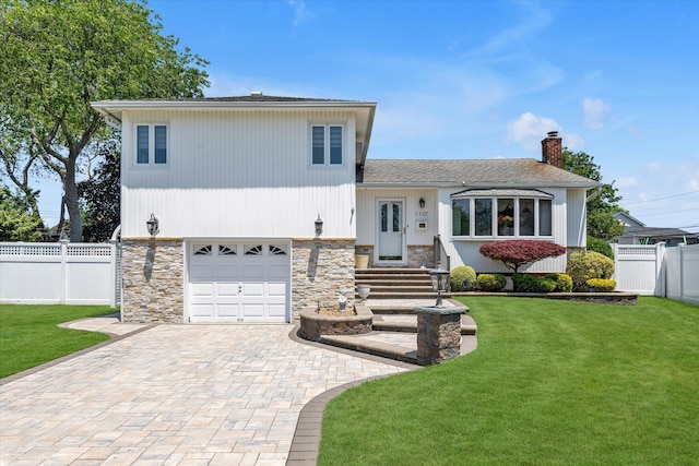 1182 Adrienne Ln, Seaford, NY 11783 - tri-level home with an attached garage, decorative driveway, a chimney, stone siding, and a shingled roof