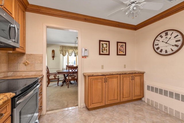 1182 Adrienne Ln, Seaford, NY 11783 - kitchen featuring radiator heating unit, appliances with stainless steel finishes, ornamental molding, brown cabinetry, and ceiling fan