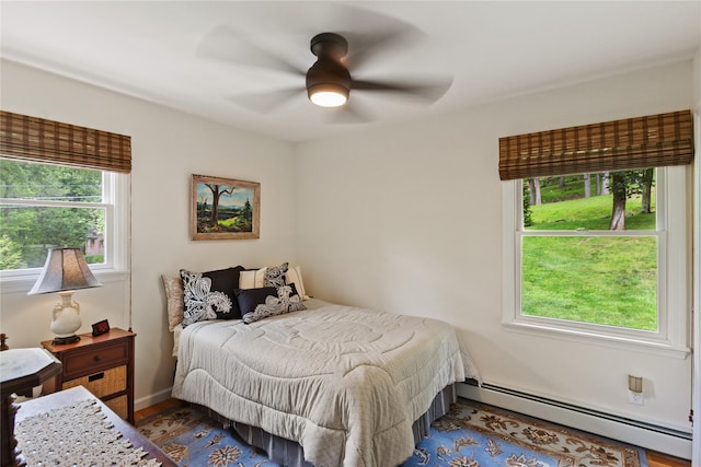 1 Hawthorne Ct, North Salem, NY 10560 - bedroom featuring a baseboard radiator, multiple windows, wood finished floors, and a ceiling fan