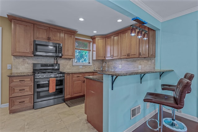 72 Harris Ave, Hewlett, NY 11557 - kitchen featuring stainless steel appliances, a breakfast bar area, crown molding, dark stone countertops, and tasteful backsplash