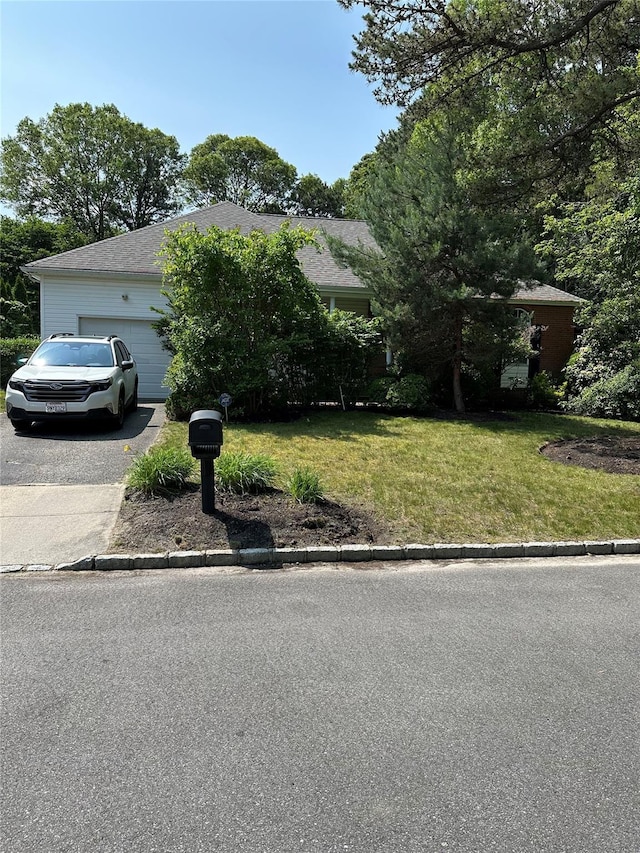 61 Timber Ridge Dr, Coram, NY 11727 - view of property hidden behind natural elements featuring a front lawn, driveway, and an attached garage