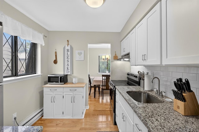 129 Main St Unit D12, Cornwall, NY 12518 - kitchen featuring appliances with stainless steel finishes, under cabinet range hood, light wood-type flooring, and healthy amount of natural light