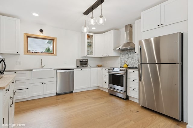 50 N Chestnut St, Beacon, NY 12508 - kitchen with appliances with stainless steel finishes, wall chimney range hood, white cabinets, decorative backsplash, and glass insert cabinets
