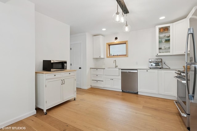 50 N Chestnut St, Beacon, NY 12508 - kitchen featuring appliances with stainless steel finishes, light wood-type flooring, white cabinets, recessed lighting, and glass insert cabinets