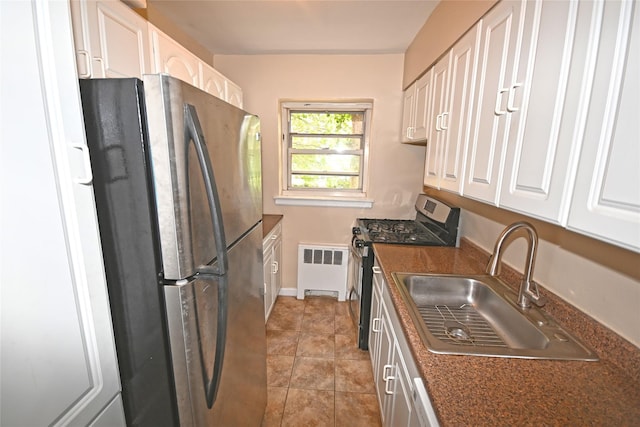 221 Middle Neck Rd Unit I-3, Great Neck, NY 11021 - kitchen featuring appliances with stainless steel finishes, radiator heating unit, dark countertops, and white cabinets
