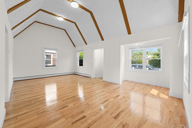 131-36 Francis Lewis Blvd, Laurelton, NY 11413 - unfurnished living room with a baseboard heating unit, wood finished floors, a textured ceiling, and high vaulted ceiling