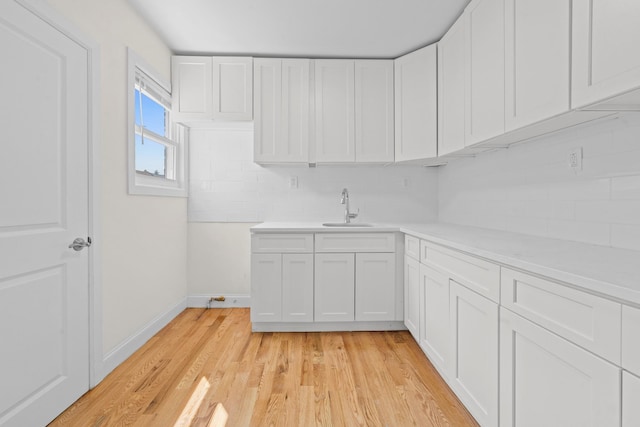 131-36 Francis Lewis Blvd, Laurelton, NY 11413 - kitchen with tasteful backsplash, light countertops, light wood-style floors, and white cabinets