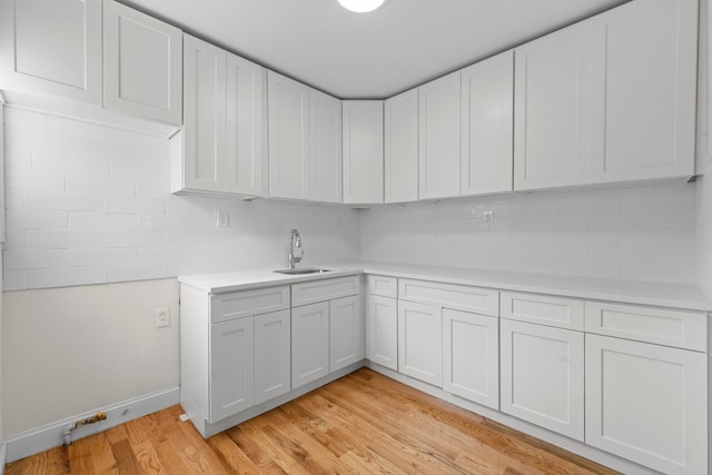 131-36 Francis Lewis Blvd, Laurelton, NY 11413 - kitchen with light countertops, backsplash, light wood finished floors, and white cabinets