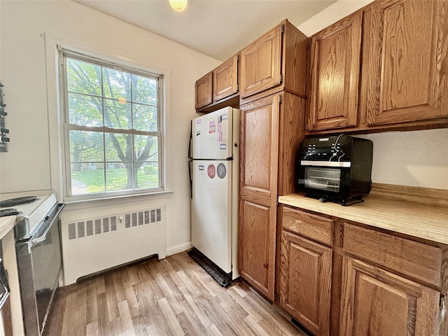 182 Pinewood Rd Unit 28, Hartsdale, NY 10530 - kitchen featuring white appliances, radiator, and brown cabinetry