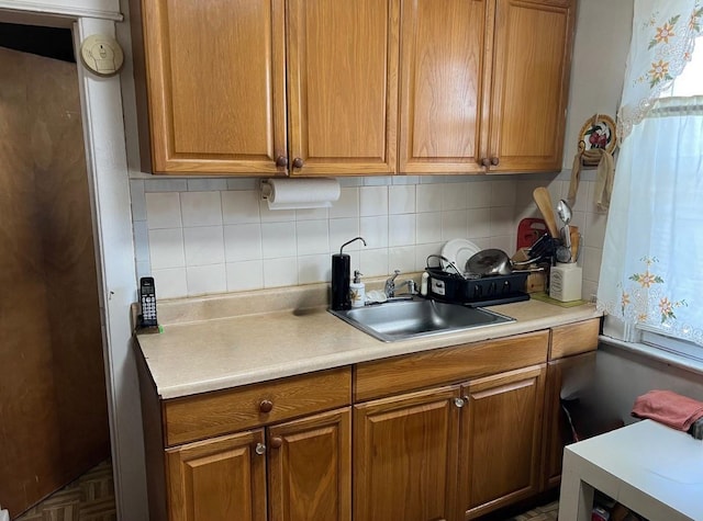 14 Matthews Pl, Brooklyn, NY 11236 - kitchen with brown cabinetry, decorative backsplash, light countertops, and plenty of natural light