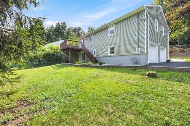 52 Broadway, Piermont, NY 10968 - back of property featuring stairway, a wooden deck, a garage, a lawn, and asphalt driveway