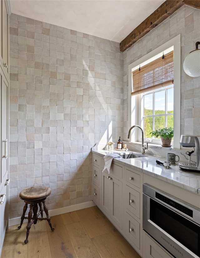 1174 Potter Mountain Rd, Gilboa, NY 12076 - kitchen with tile walls, light wood-style flooring, and light stone countertops
