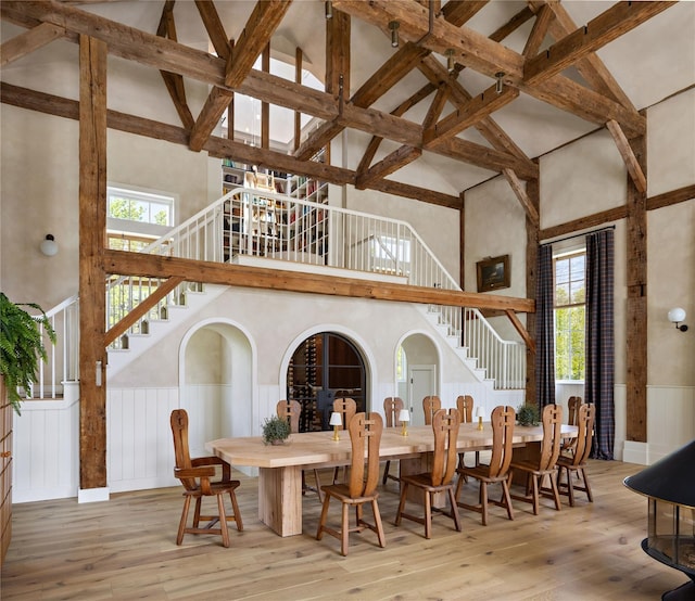 1174 Potter Mountain Rd, Gilboa, NY 12076 - dining space featuring stairway, high vaulted ceiling, a wainscoted wall, hardwood / wood-style flooring, and healthy amount of natural light