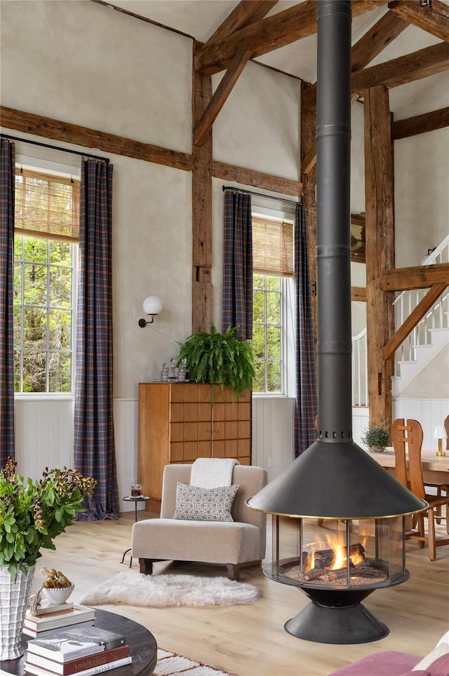 1174 Potter Mountain Rd, Gilboa, NY 12076 - living area featuring wood finished floors, healthy amount of natural light, a wood stove, a high ceiling, and stairway