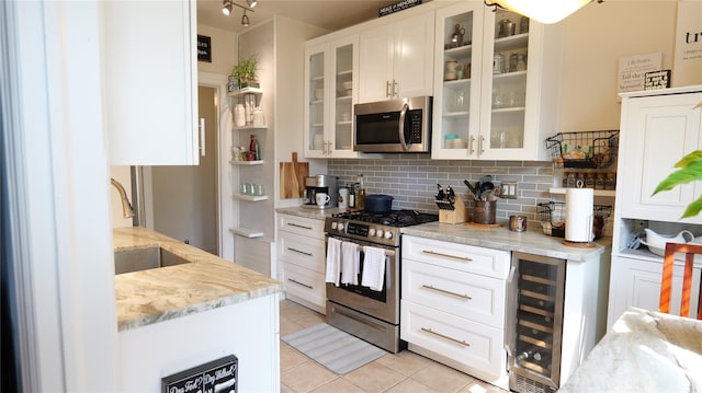 445 Gramatan Ave Unit Hc2, Mount Vernon, NY 10552 - kitchen with wine cooler, stainless steel appliances, light tile patterned flooring, decorative backsplash, and white cabinets