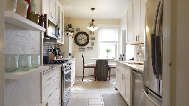 445 Gramatan Ave Unit Hc2, Mount Vernon, NY 10552 - kitchen featuring stainless steel appliances, white cabinetry, light tile patterned floors, decorative light fixtures, and wainscoting