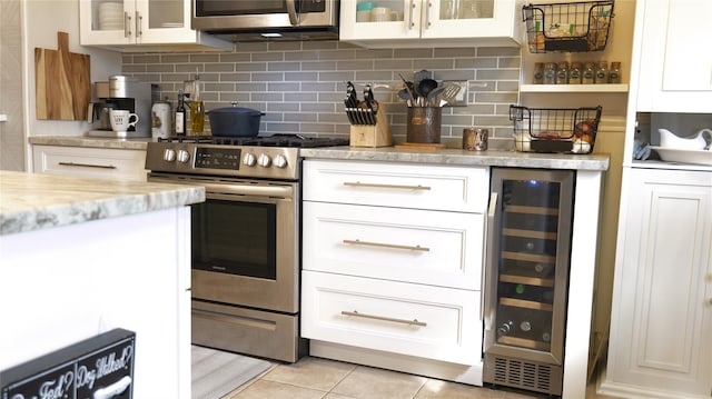 445 Gramatan Ave Unit Hc2, Mount Vernon, NY 10552 - kitchen featuring stainless steel appliances, beverage cooler, light tile patterned floors, decorative backsplash, and glass insert cabinets