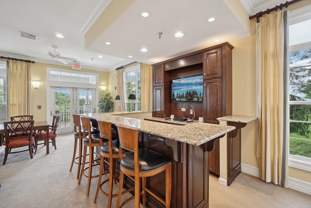 2602 Hawthorn Way, New Windsor, NY 12553 - kitchen featuring light carpet, ornamental molding, recessed lighting, a kitchen island, and a breakfast bar area