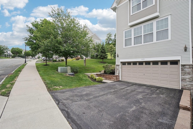 2602 Hawthorn Way, New Windsor, NY 12553 - view of side of home featuring a garage, asphalt driveway, stone siding, and a lawn