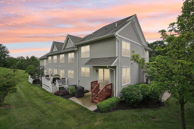 2602 Hawthorn Way, New Windsor, NY 12553 - back of property at dusk featuring a yard, a patio, and roof with shingles