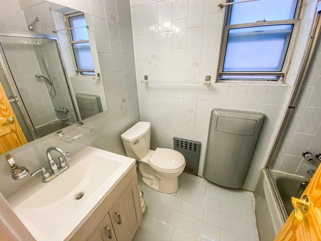 1365 Crosby Ave, Bronx, NY 10461 - full bathroom with radiator, tile walls, plenty of natural light, vanity, and bath / shower combo with glass door