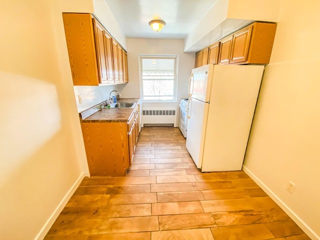 1365 Crosby Ave, Bronx, NY 10461 - kitchen featuring white appliances, radiator heating unit, light wood-style floors, and brown cabinetry