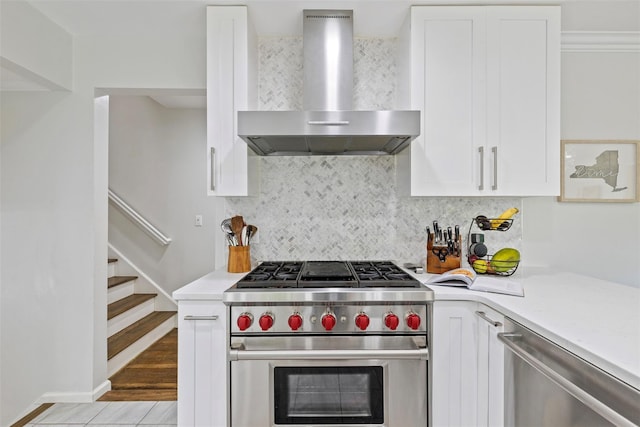 8 Sylvan Ln, Scarsdale, NY 10583 - kitchen featuring wall chimney range hood, stainless steel appliances, light countertops, and white cabinetry
