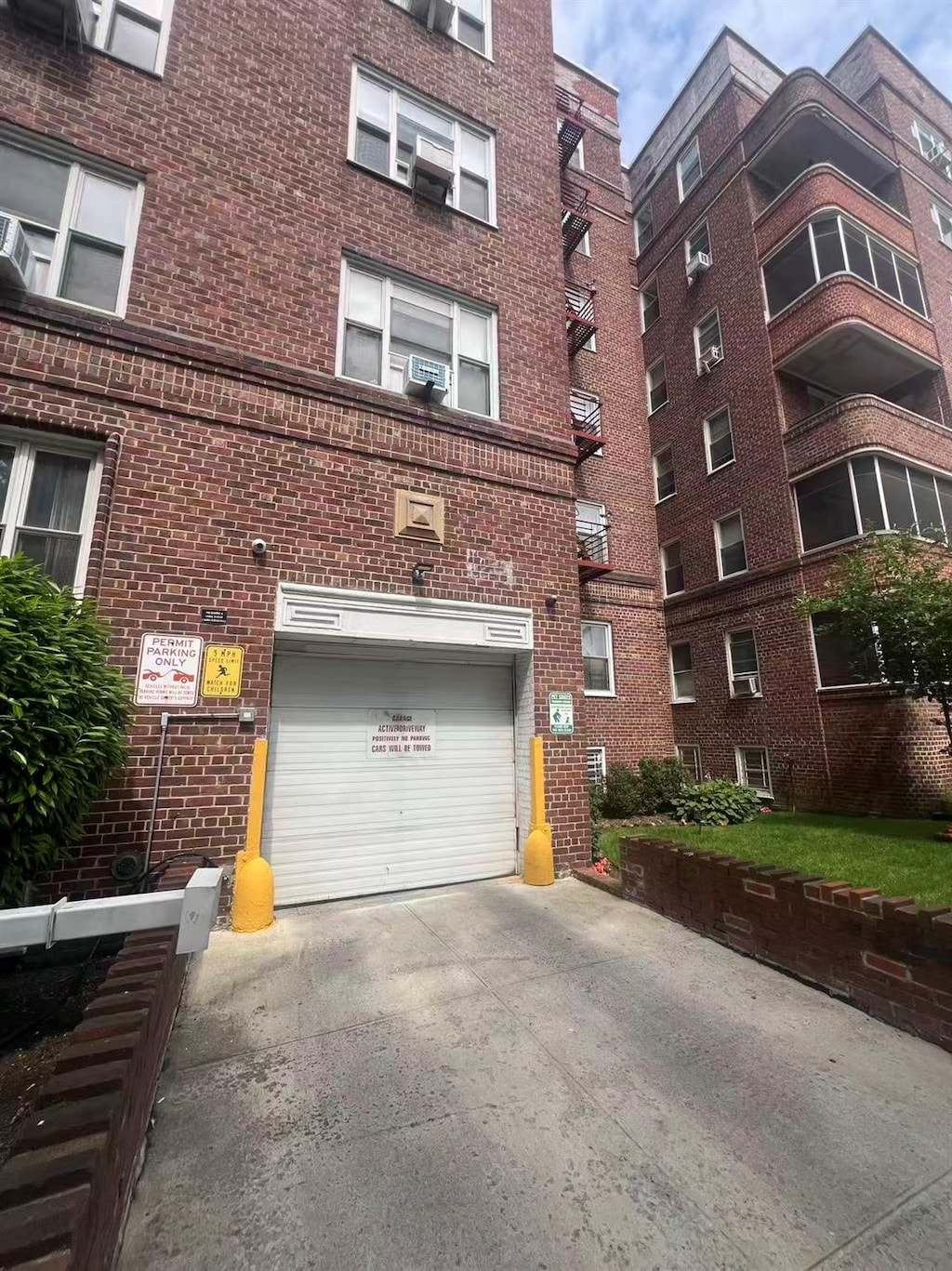 83-33 Austin St Unit 2C, Kew Gardens, NY 11415 - view of property featuring an attached garage and concrete driveway