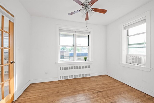 83-33 Austin St Unit 2C, Kew Gardens, NY 11415 - unfurnished room with radiator heating unit, light wood-style flooring, ceiling fan, and cooling unit