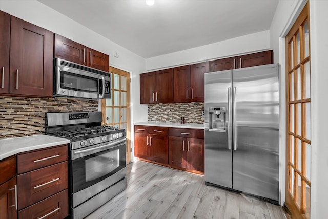 83-33 Austin St Unit 2C, Kew Gardens, NY 11415 - kitchen with appliances with stainless steel finishes, light wood-style floors, light countertops, and backsplash