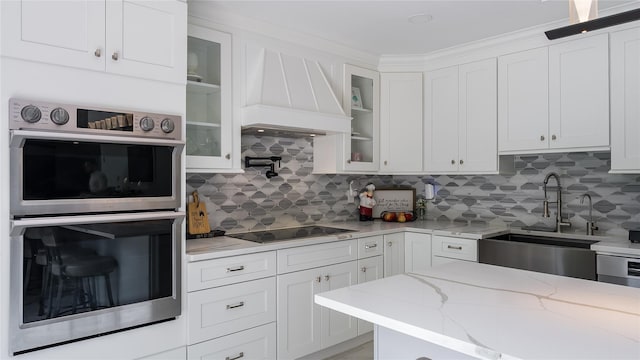 55 Charm City Dr, Port Jefferson Station, NY 11776 - kitchen with stainless steel double oven, black electric cooktop, white cabinetry, and tasteful backsplash