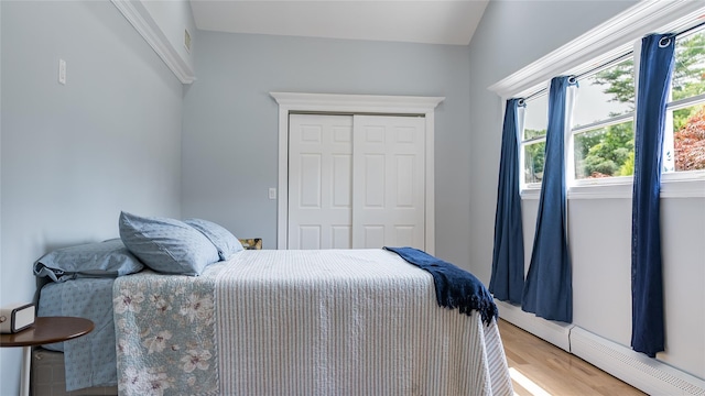 55 Charm City Dr, Port Jefferson Station, NY 11776 - bedroom featuring baseboard heating, a closet, and light wood-style flooring