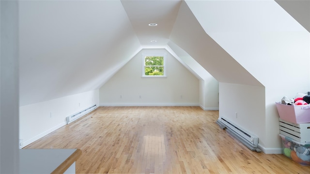 55 Charm City Dr, Port Jefferson Station, NY 11776 - additional living space featuring baseboard heating, light wood finished floors, and vaulted ceiling