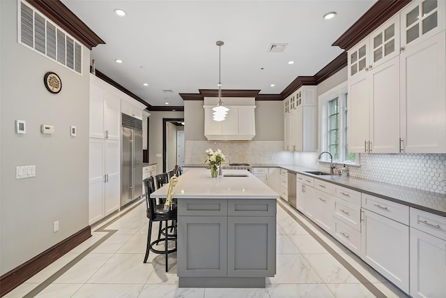 3747 Purchase St, Purchase, NY 10577 - kitchen with ornamental molding, stainless steel appliances, a kitchen bar, white cabinets, and decorative backsplash