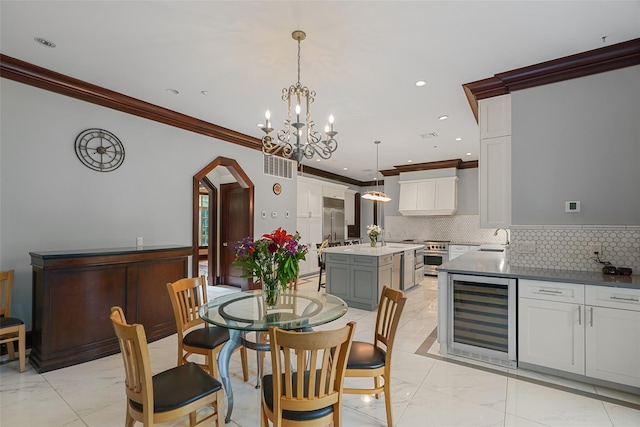 3747 Purchase St, Purchase, NY 10577 - dining area featuring wine cooler, light marble finish flooring, ornamental molding, a chandelier, and recessed lighting