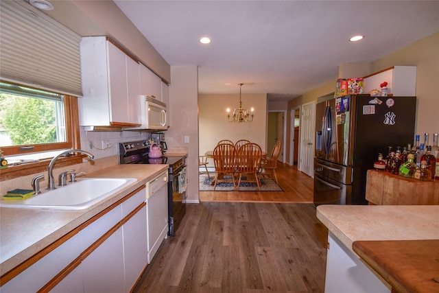 805 Canal Rd, Mount Sinai, NY 11766 - kitchen featuring white appliances, white cabinetry, dark wood-style floors, light countertops, and a chandelier