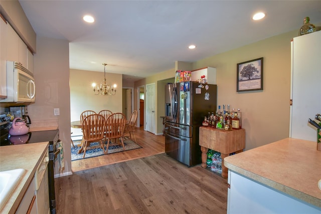 805 Canal Rd, Mount Sinai, NY 11766 - kitchen with white microwave, electric stove, stainless steel fridge with ice dispenser, wood finished floors, and white cabinetry