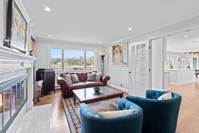 8 Pippin Ln, Lloyd Harbor, NY 11743 - living room featuring plenty of natural light, ornamental molding, a glass covered fireplace, recessed lighting, and light wood-style flooring