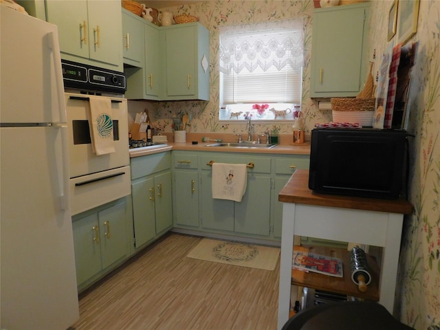 1879 Crompond Rd Unit # D15, Peekskill, NY 10566 - kitchen featuring white appliances, green cabinetry, a warming drawer, wallpapered walls, and light wood finished floors